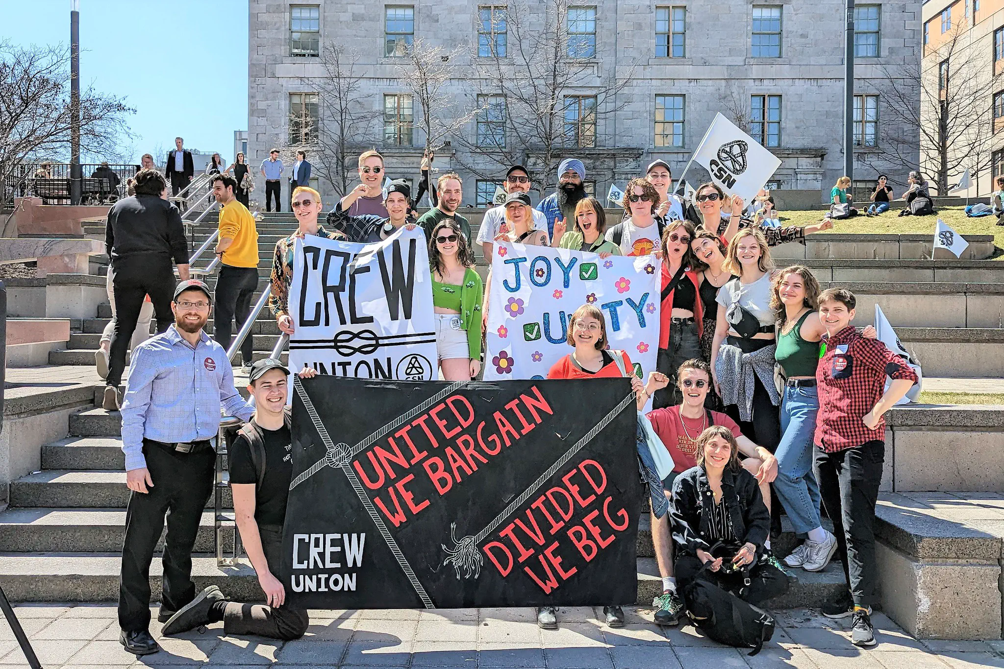 Photo of AGSEM President Mario Roy (far left) and Mobilization Officer Kiersten van Vliet (far right) pose with militants from the Concordia Research and Education Workers’ Union (CREW-CSN) at the “We Can Win a Huge Raise: AGSEM Rally for TAs” rally (April 13, 2023).